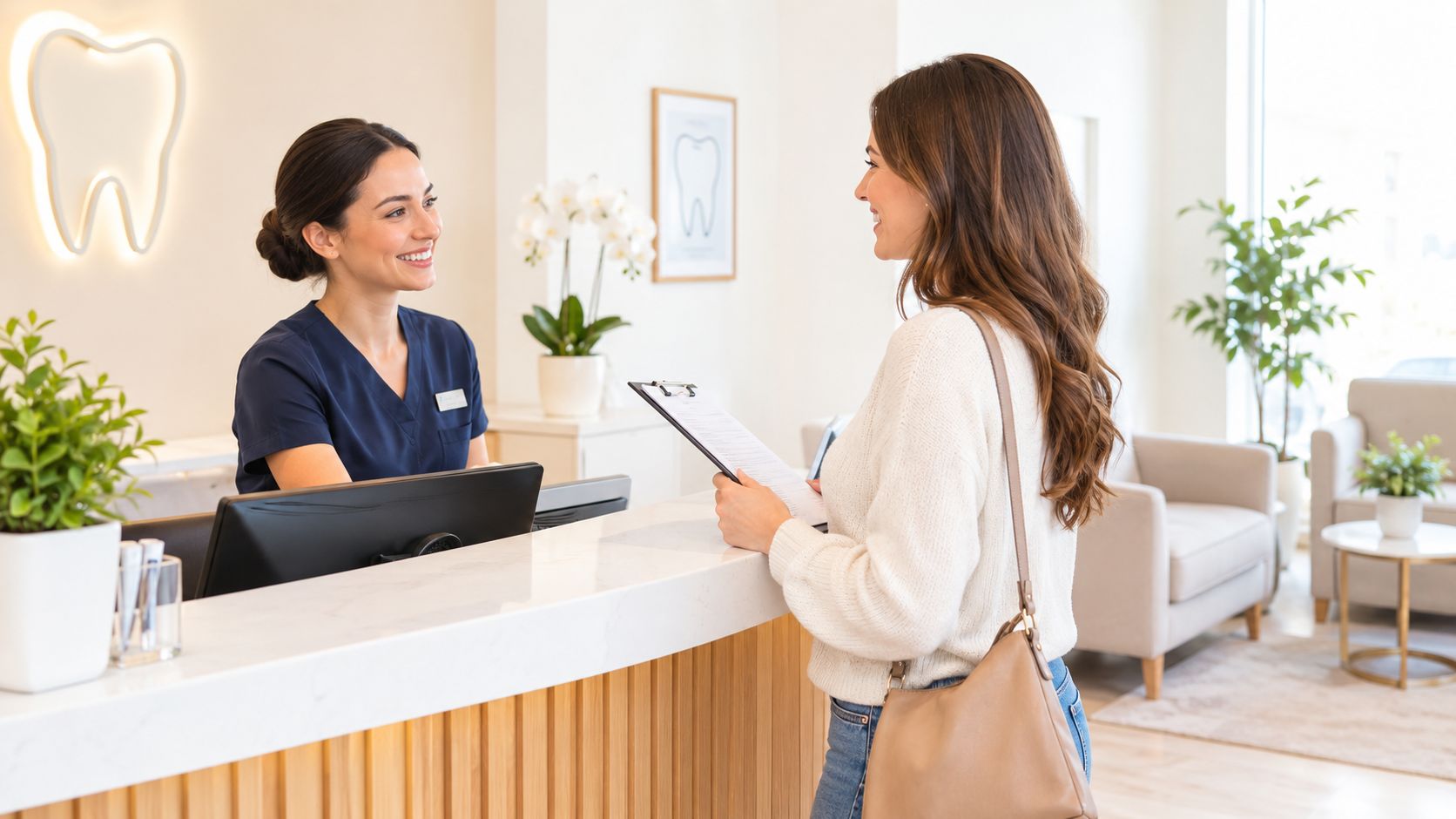 A smiling dental receptionist assisting a patient with paperwork at a modern, clean dental office front desk.